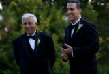 Joseph Gatto standing to the left of Mike Gatto, both wearing black tuxedos. They smile toward the same direction to the left.